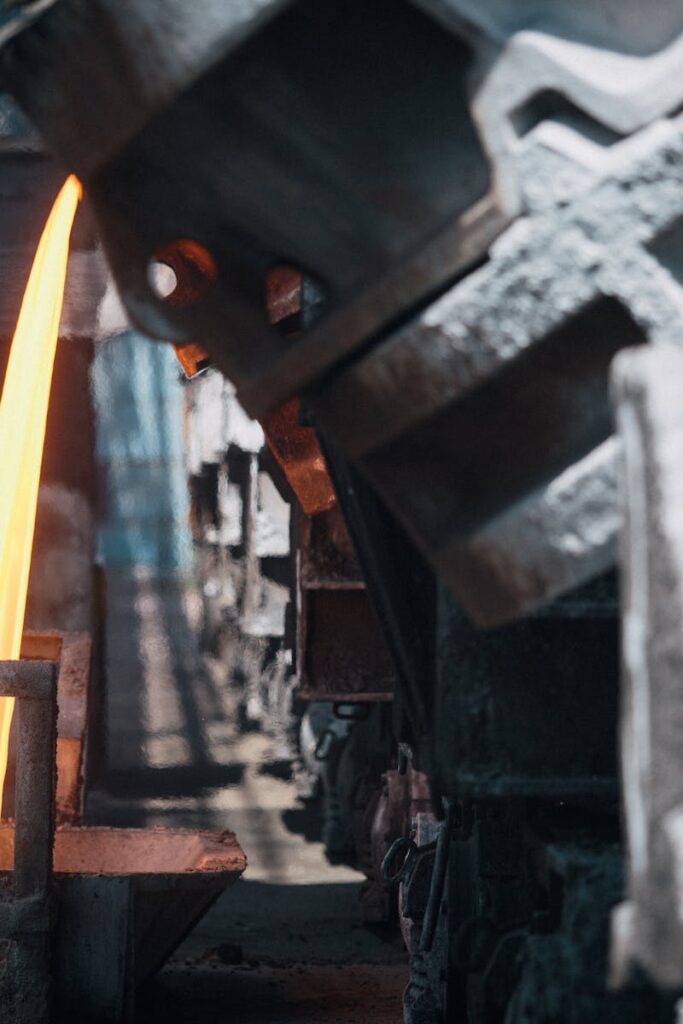 A powerful image of molten metal pouring in a heavy industry steel mill setting.